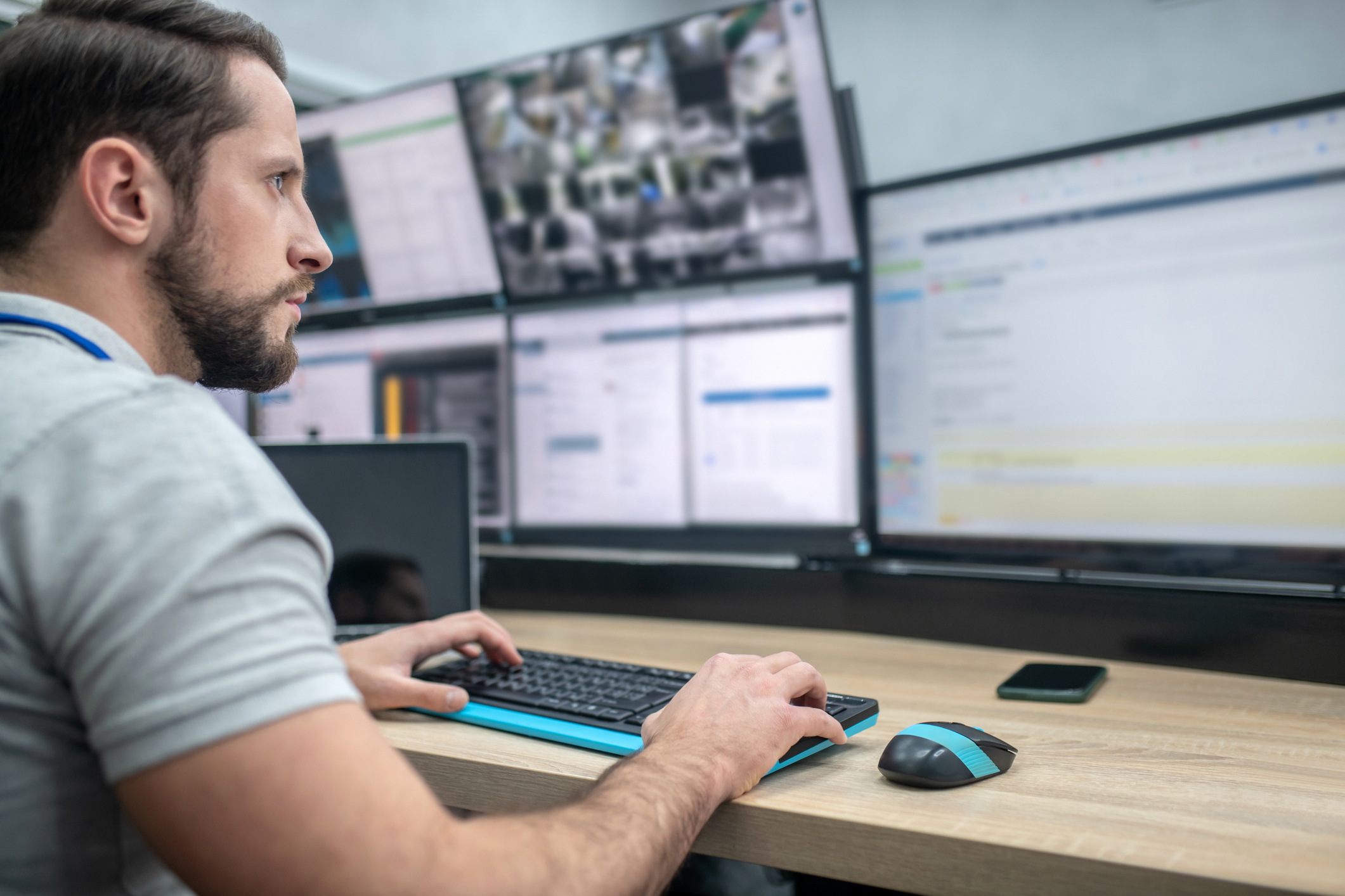 a man is looking at a computer system monitoring the network it is managing