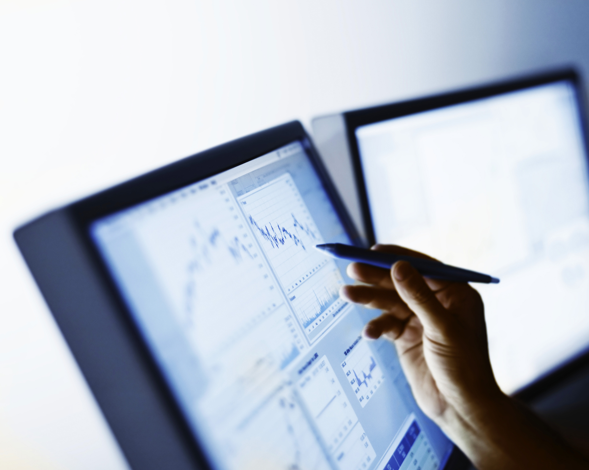 a hand pointing at something on the surface of a computer screen