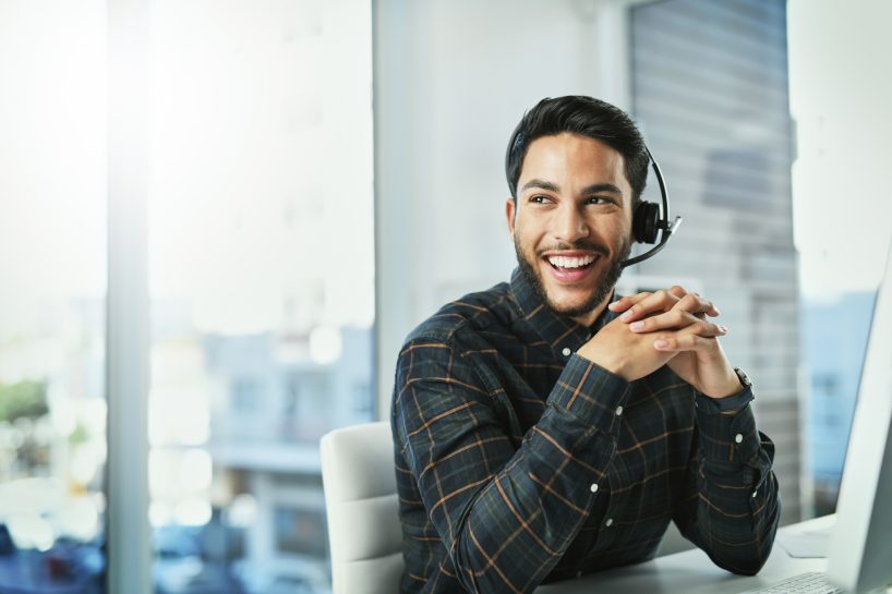 Portrait of a handsome young call centre agent working in his office